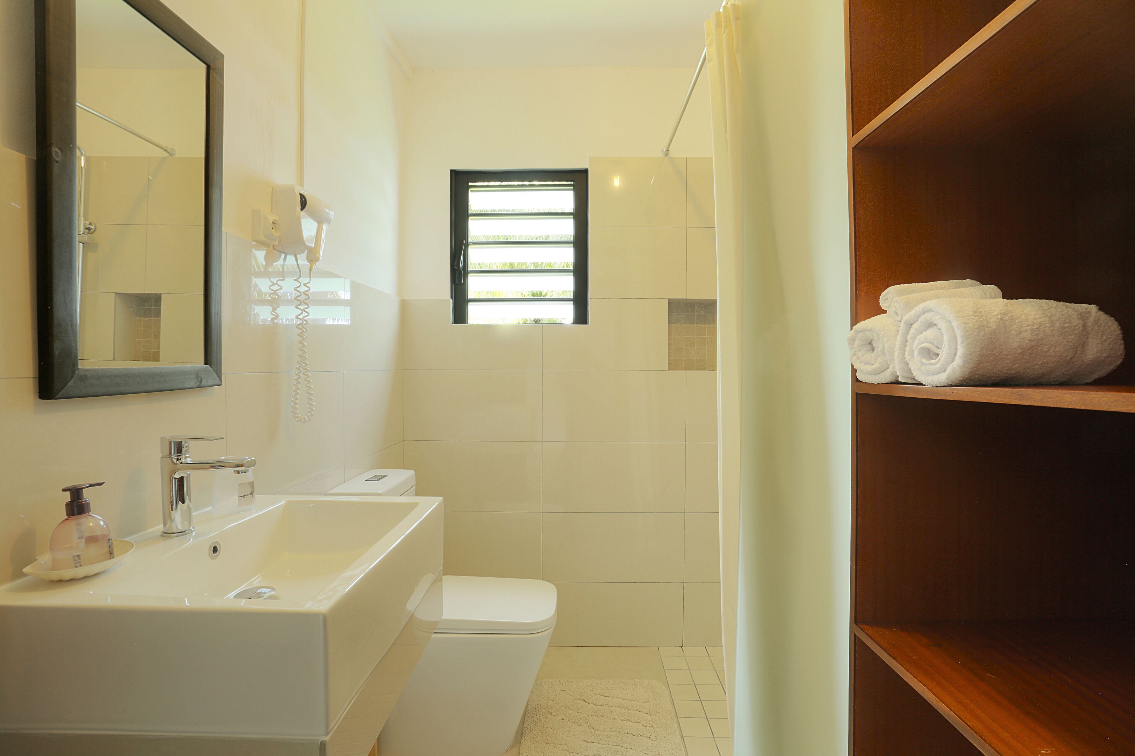 A bathroom with a sink, toilet, and a shower area.