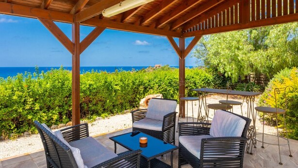 A covered outdoor seating area with a view of the sea and vineyards. - Villa Erato - Three Bedroom Villa, Sleeps 6 (Nea Dimmata)