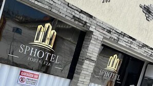 On peut voir la façade d’un hôtel avec les inscriptions « SPHOTEL » et « FORTALE FZA ». Deux panneaux indiquent qu’il est interdit de se garer.