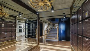 A modern interior with a staircase, lockers, and a unique ceiling sculpture. - Apartament RELAKS (Zakopane)
