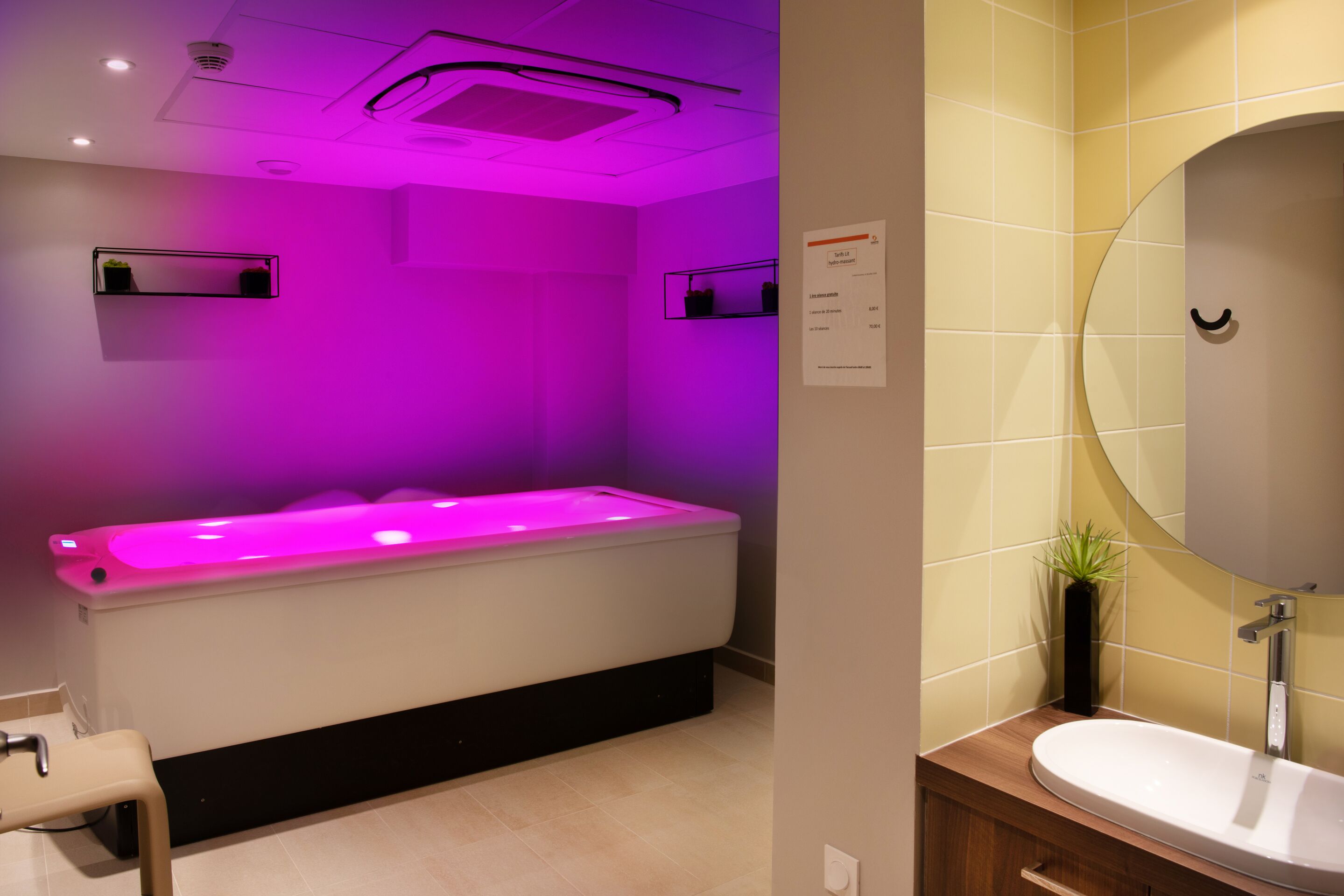 Un baño moderno con suelo calefactado, bañera, lavabo y espejo.