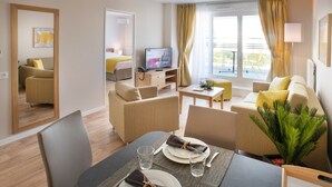 Une chambre d’hôtel moderne dotée d’un coin repas, d’un espace de vie et d’un balcon.