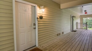 A wooden deck with a white door and a light fixture. - Condo w/ Pool Access ~ 2 Mi to Rehoboth Beach! (Rehoboth Beach)