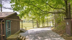 A rustic cabin with a gravel path leading to a picnic table and a bench, surrounded by trees. - 2 Mi to Green Bank Observatory! Mtn-View Cabin (Green Bank)