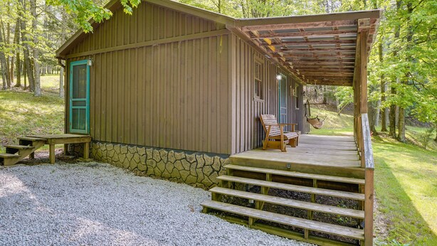 A rustic cabin with a wooden exterior, a stone foundation, and a porch with steps leading to a bench. - 2 Mi to Green Bank Observatory! Mtn-View Cabin (Green Bank)