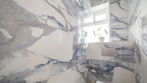 Et badeværelse med marmorvægge og en moderne vask.