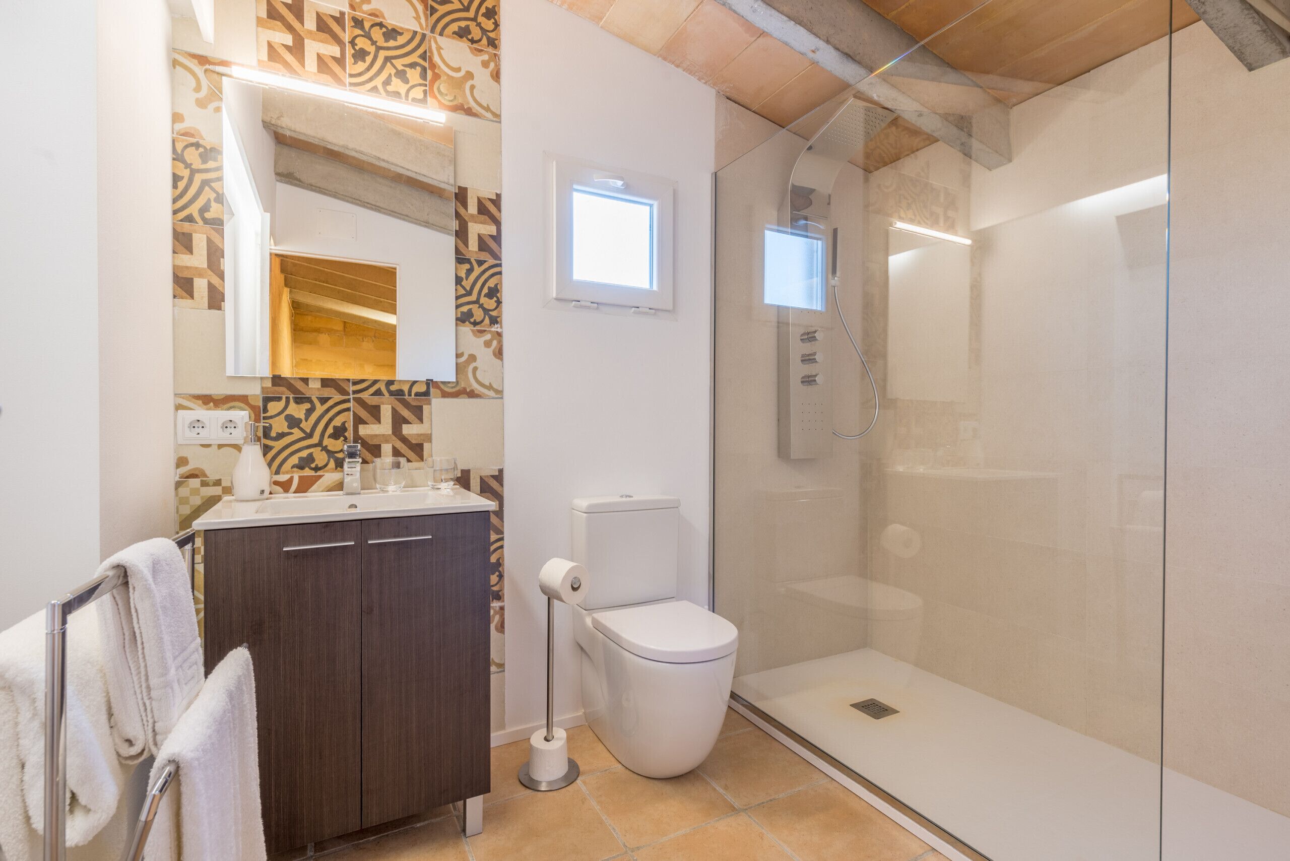 A modern bathroom with a shower, toilet, and vanity.