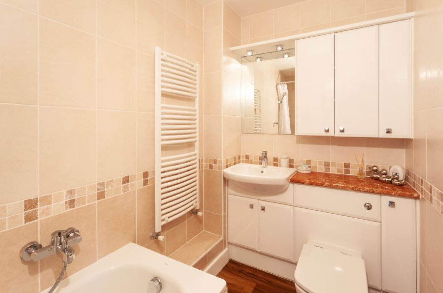 A bathroom with a bathtub, sink, toilet, and a towel rack.