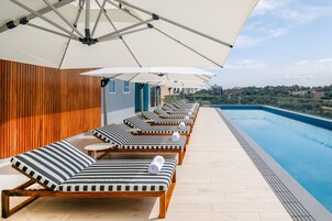 Una piscina al aire libre, sombrillas