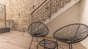 Two black wireframe chairs on a wooden deck with a stone wall and a staircase in the background. - AT WOLF HOUSE, ELEGANT PANORAMIC HOUSE (Cison di Valmarino)