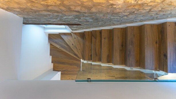 A staircase with wooden steps and a glass railing, leading to a stone ceiling. - AT WOLF HOUSE, ELEGANT PANORAMIC HOUSE (Cison di Valmarino)