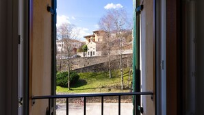 A balcony with a view of a hillside and buildings in the background. - AT WOLF HOUSE, ELEGANT PANORAMIC HOUSE (Cison di Valmarino)
