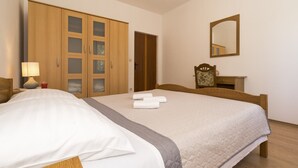 A hotel room with a large bed, wooden wardrobe, a mirror, and a bedside table with a lamp. - Vacation House With the Pool, Near River Cetina (Omis)