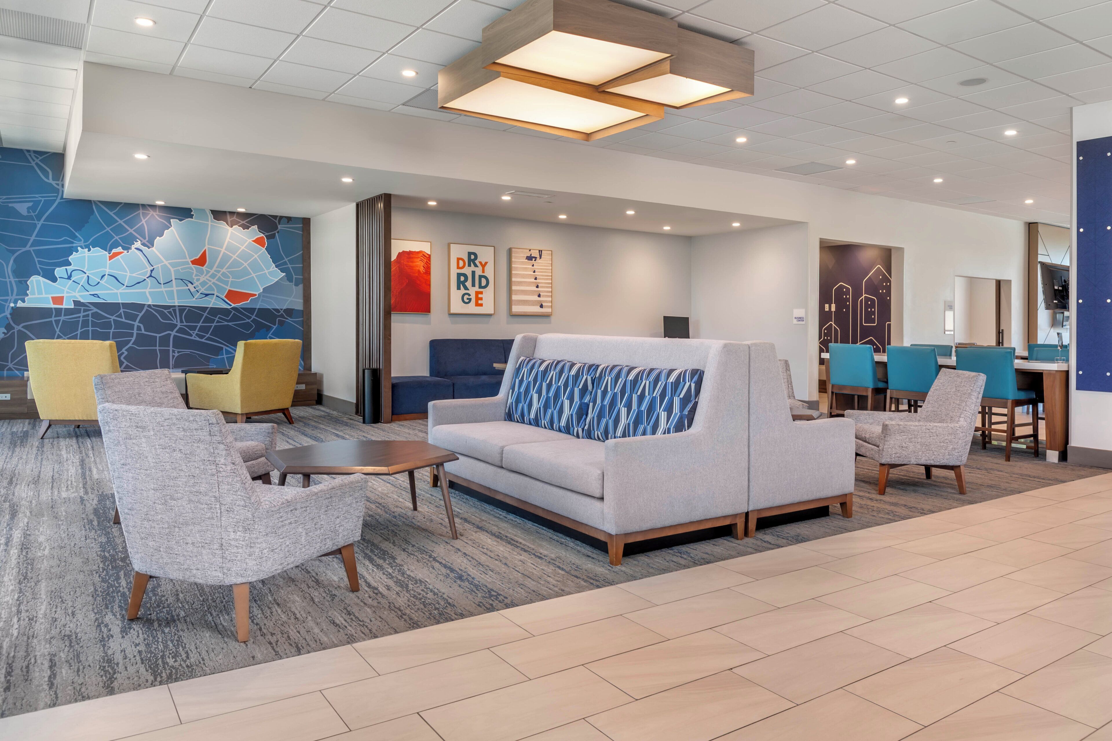 A modern lobby with a seating area, a map wall, and a business center.