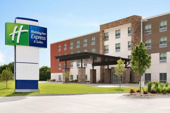 A Holiday Inn Express & Suites building with a modern design, featuring a covered entrance and a landscaped area with trees and shrubs. - Holiday Inn Express and Suites Dry Ridge by IHG (Dry Ridge)