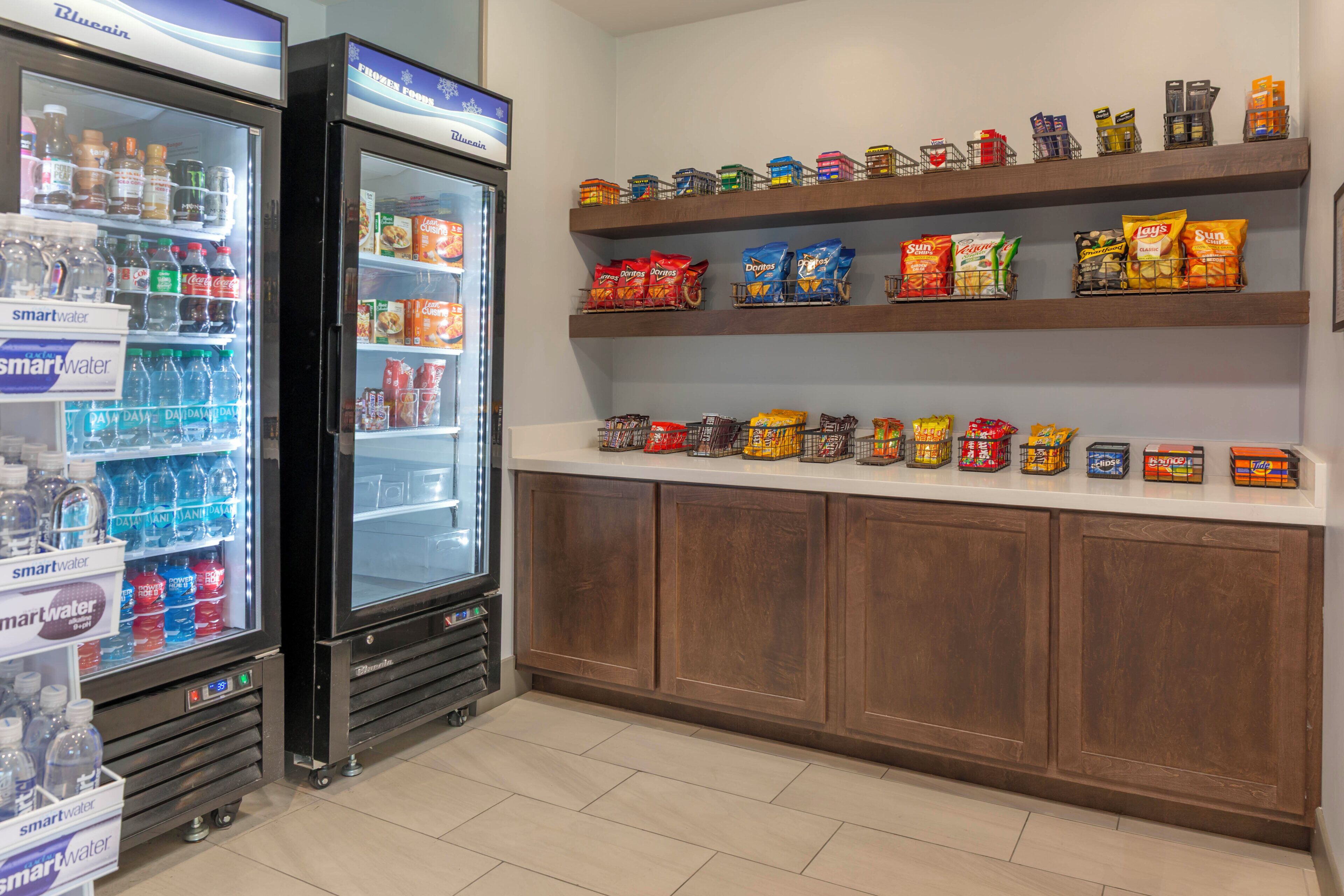 A snack and beverage section with refrigerated drinks and a variety of snacks on shelves.