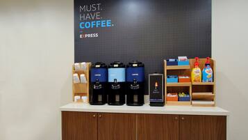 Una estación de café con varios dispensadores, un calentador de agua y diferentes productos de café en estantes.