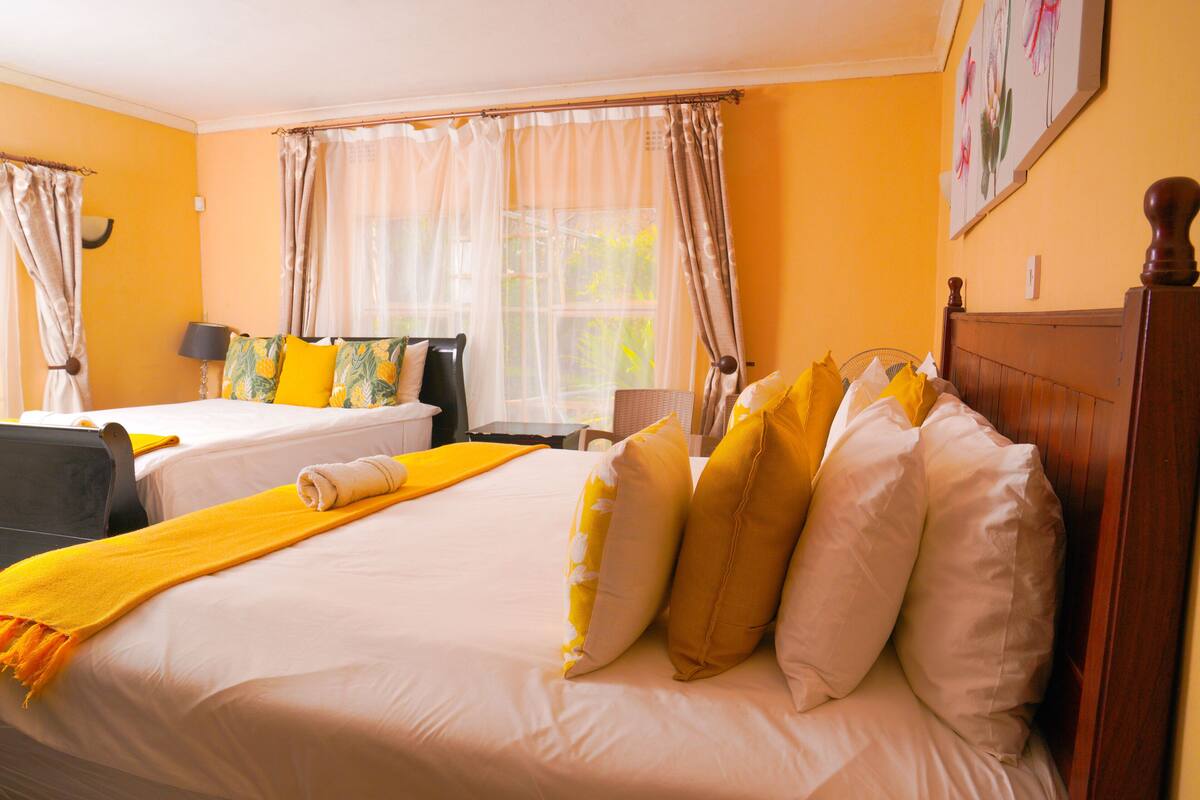 Une chambre d’hôtel avec deux lits, un bureau et une chaise.