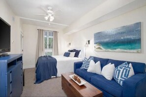Relax in this inviting room with a neatly made bed, sofa, and flat-screen TV.
