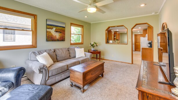 A living room with a sofa, a wooden coffee table, a television, and a ceiling fan. - Dog-Friendly Watertown Vacation Rental w/ Deck (Watertown)