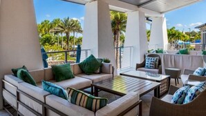 An outdoor patio with cushioned seating, a table, and a ceiling fan.