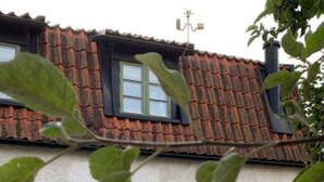A house with a red-tiled roof, a wooden door, and a small window. - Charmant 1 RoK Visby Innerstad, last round (Gotlands län)