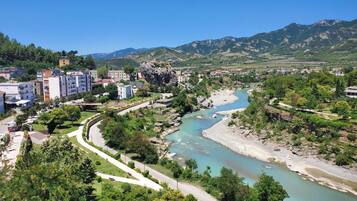A river flowing through a town with buildings and mountains in the background.