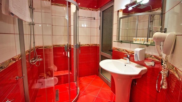 Un baño con cabina de ducha de vidrio, un lavabo y un espejo.