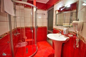 Un baño con cabina de ducha de vidrio, un lavabo y un espejo.