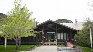 A fitness center with a covered entrance, steps leading up to the door, and a flag in front. - Ski, RIde, Walk On/Off Condo On Pico at Killington
 (Killington)