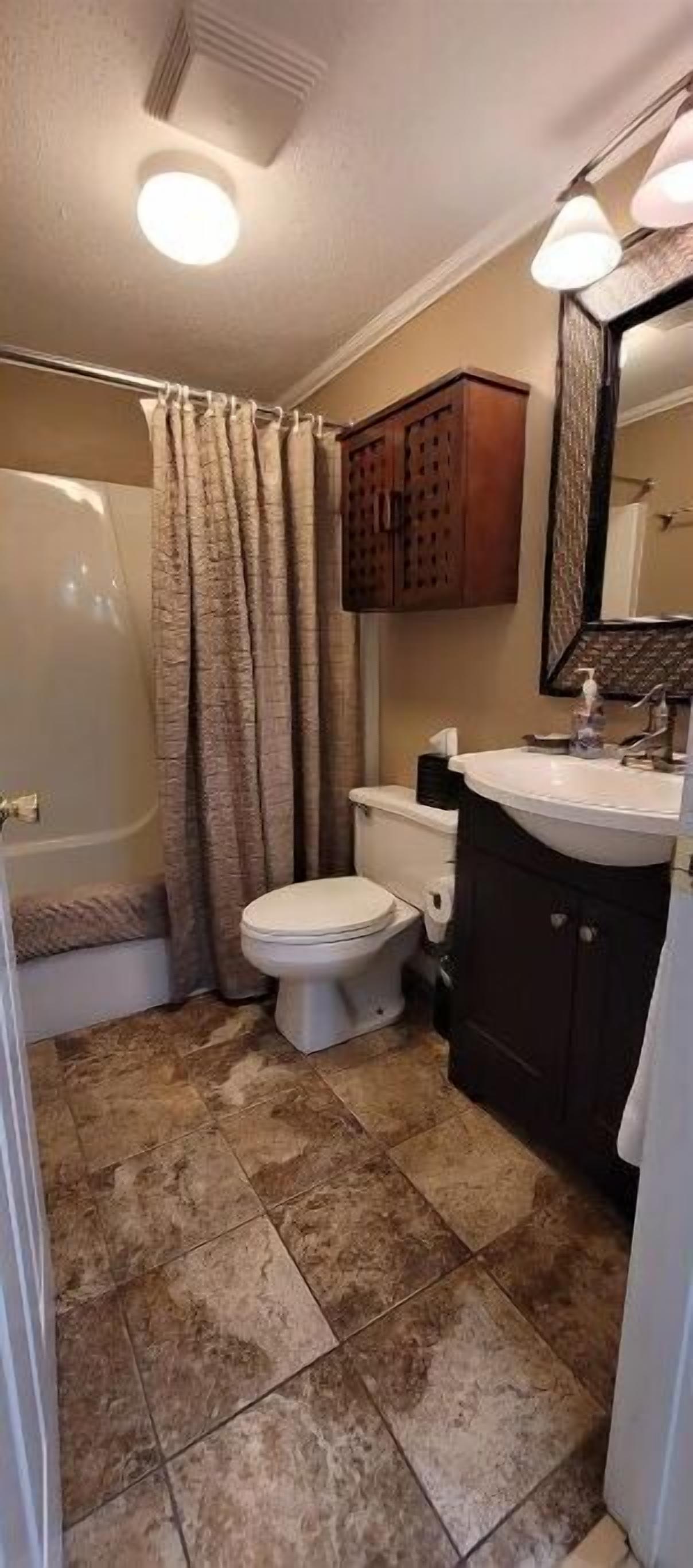 Une salle de bain avec des toilettes, une douche et un lavabo.