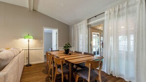 Un comedor con una mesa y sillas de madera, una lámpara de pie y una planta.