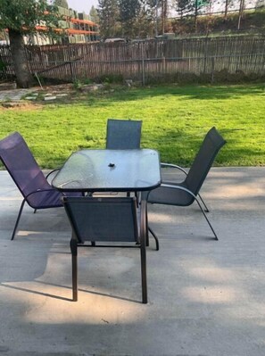 Enjoy dining or socializing in this outdoor space with a glass-top table and comfortable seating for four.