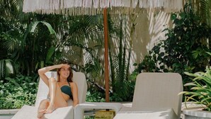 A pool area with lounge chairs and a decorative umbrella. - Amnaya Resort Nusa Dua (Nusa Dua)