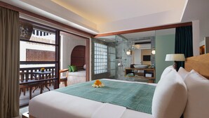 A hotel room with a bed, a bathroom with a large mirror, a seating area with a view, and a balcony. - Amnaya Resort Nusa Dua (Nusa Dua)