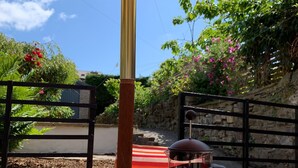 A wooden table with a striped umbrella, two patterned cups, a coffee pot, and a croissant. - Spacious Lancaster city centre hide away with garden. (Lancaster)