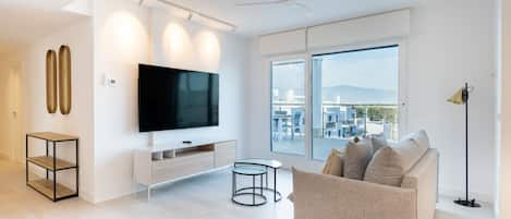 Una sala moderna con un televisor de pantalla plana grande, un sofá y un comedor.