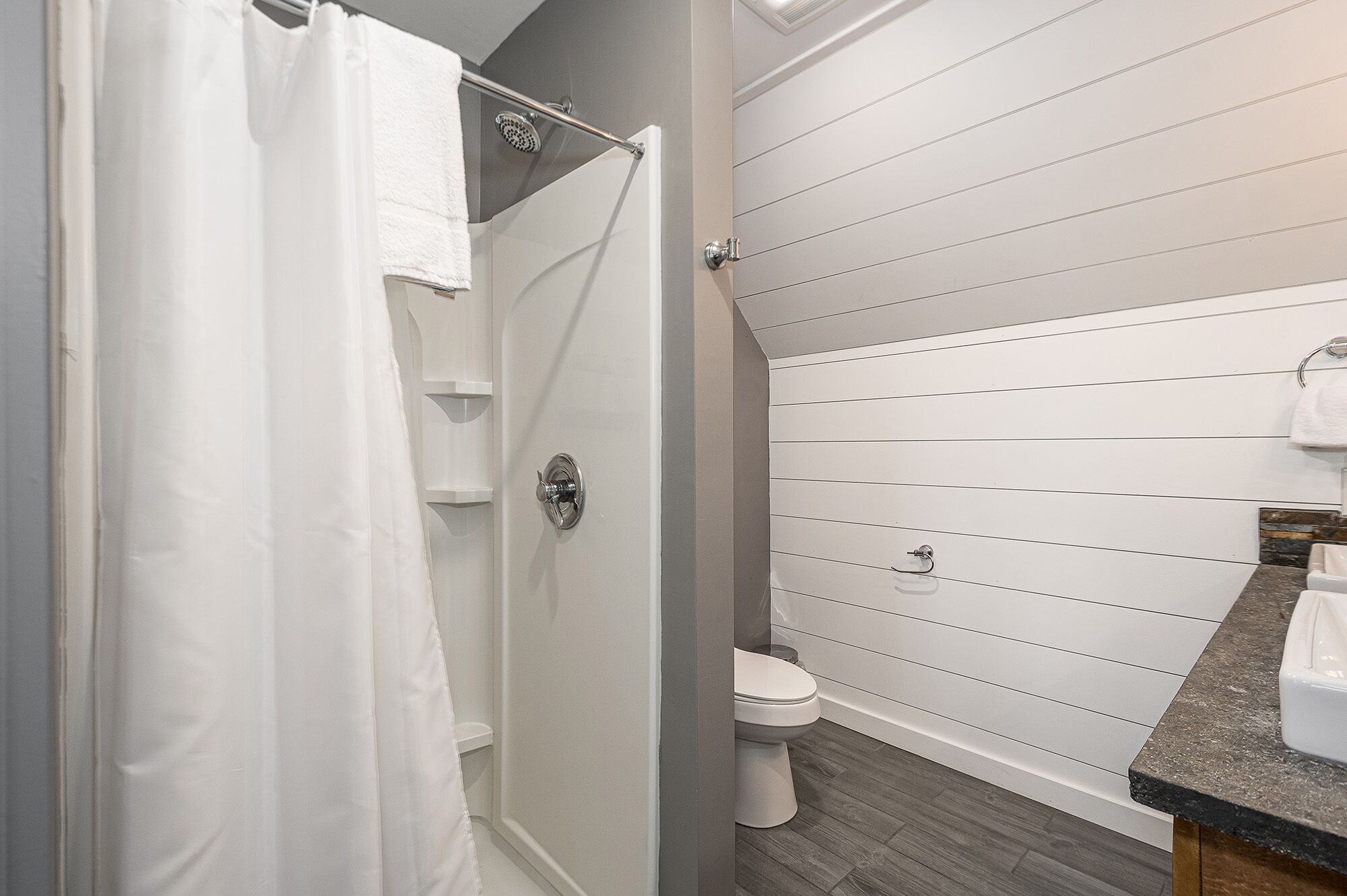 Une salle de bain équipée d’une douche, de toilettes et d’un lavabo avec un plan de toilette en marbre.