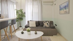 A modern living room with a sofa, a round coffee table, and a potted plant.