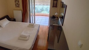 A hotel room with a bed, a desk, and a view of the outside balcony. - Paradeisos Modern, 2BR, 2BA, Fully Equipped (Chalandri)