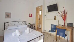 Ein Hotelzimmer mit Bett, Schreibtisch mit Stuhl, Fernseher und Heizkörper.
