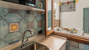Une cuisine équipée d’un évier, d’un four à micro-ondes et d’une fenêtre donnant sur un coin repas.
