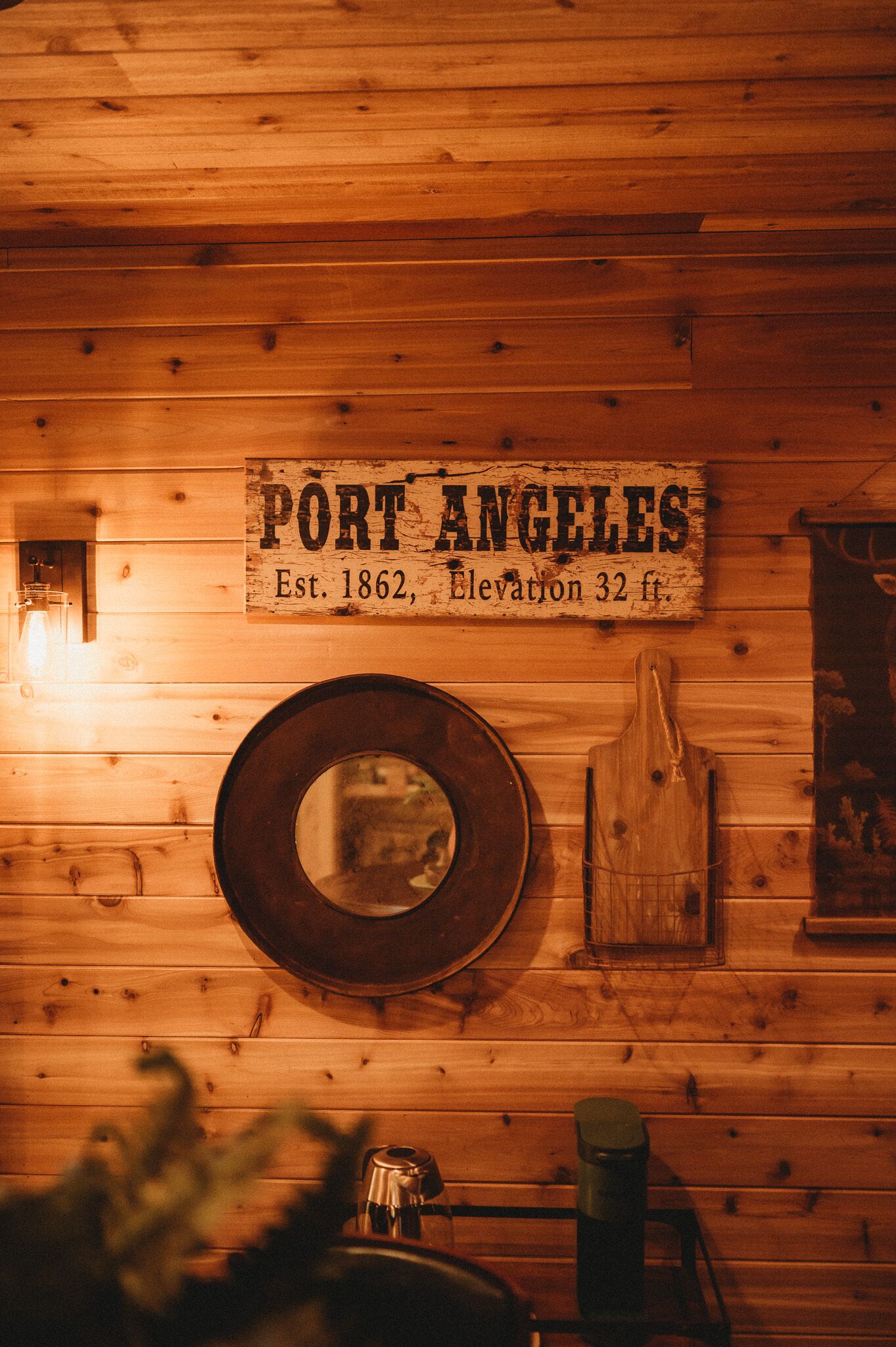 Pared de madera con un letrero que dice 'Port Angeles, fundada en 1862, altitud 32 pies'.