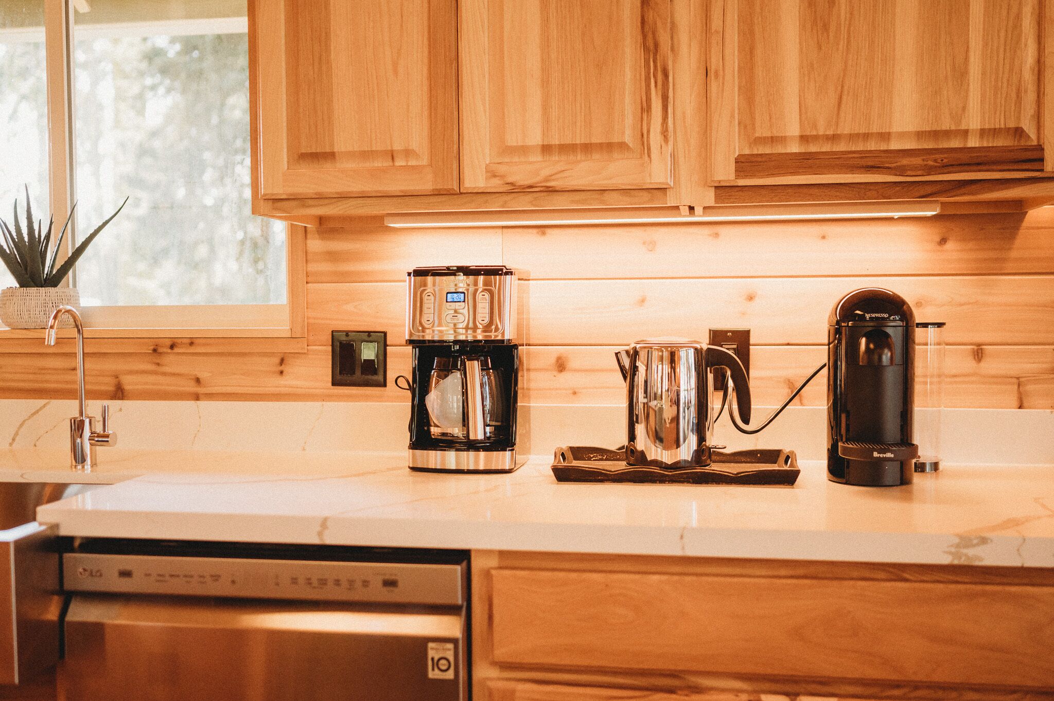 Cucina con mobili in legno, una macchina da caffè, un bollitore e un tostapane.