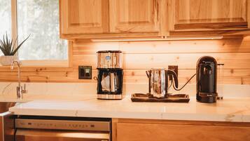 Cucina con mobili in legno, una macchina da caffè, un bollitore e un tostapane.