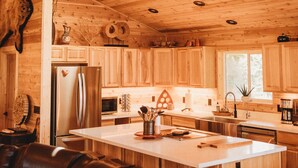 A wooden interior with a kitchen island, seating area, and a ceiling with recessed lighting. - Woodland Bluff (Port Angeles)