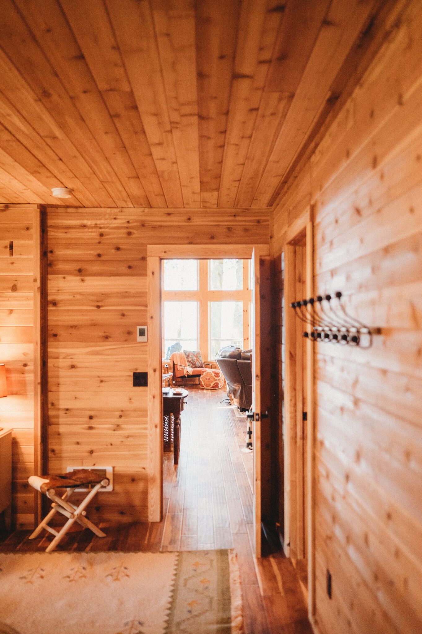 A wooden interior hallway with a door leading to a room.