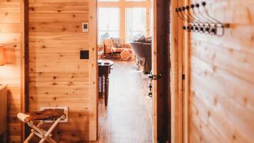 A wooden interior hallway with a door leading to a room.