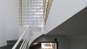 A staircase with a view of a car through an open door.