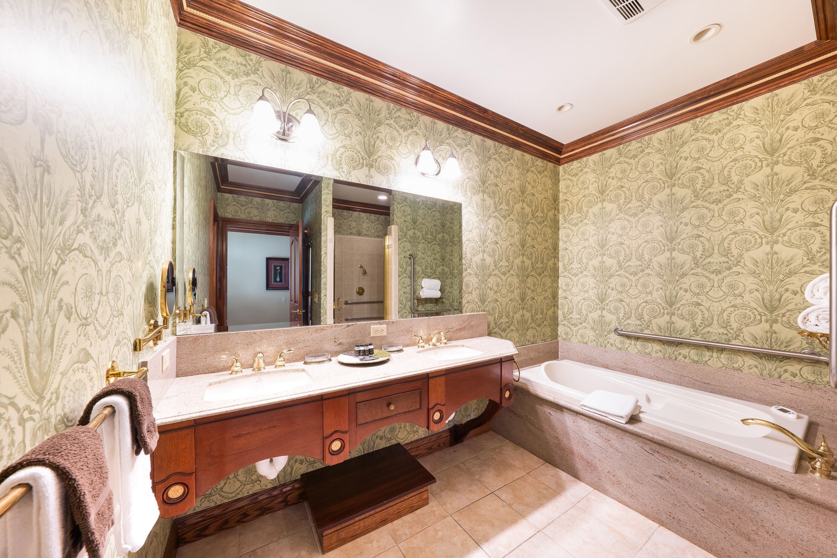 Un baño con un espejo grande, dos lavamanos, una bañera y un tocador con cajones.